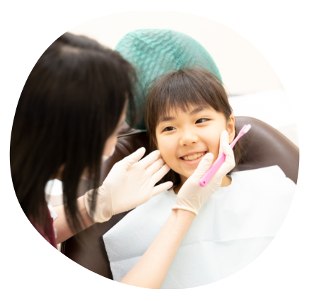 こどもが歯科衛生士さんに教えてもらってる写真